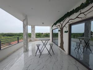 a room with a table and a tree on a balcony at Villa Hawa, Décor unique & Piscine in Somone