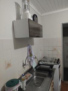 a kitchen with a sink and a stove at Casinha feliz in Guaratinguetá