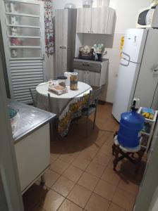 a small kitchen with a table and a refrigerator at Casinha feliz in Guaratinguetá
