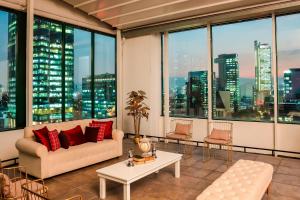 a living room with a couch and a table and windows at Sheraton Maria Isabel Mexico City Reforma in Mexico City