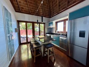 una cucina con tavolo e alcune sedie di MOOREA - Villa Ana Mua a Papetoai