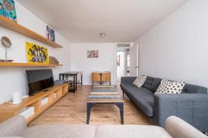 un salon avec un canapé et une télévision dans l'établissement Warm & Cosy Flat in King Cross, à Londres 16 autres photos