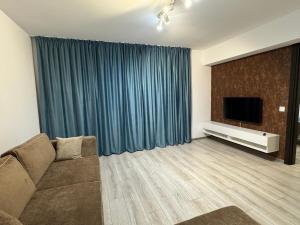a living room with a couch and a flat screen tv at 1 Mai - Luxury Park Apartments - Self check-in - Private parking 3 in Craiova