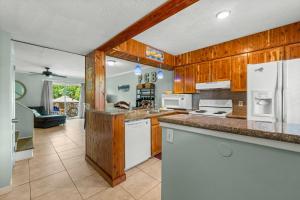 a kitchen with wooden cabinets and white appliances at Biltmore Beach Townhouse! in Panama City Beach