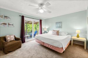 a bedroom with a bed and a chair and a window at Biltmore Beach Townhouse! in Panama City Beach +25 photos