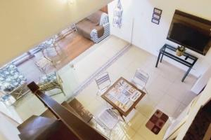 eine Draufsicht auf ein Wohnzimmer mit Tisch und Stühlen in der Unterkunft Charmoso Apartamento na Terceira praia de Morro in Morro de São Paulo + 6 Fotos
