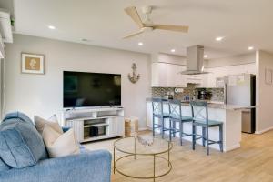 a living room with a blue couch and a kitchen at Emerald Isle Condo with Indoor Pool and Beach Access! in Emerald Isle