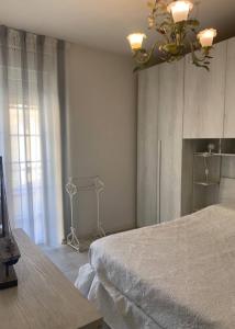 una camera da letto con un letto e un lampadario di La casa di Ely a Viareggio