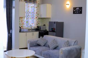a living room with a couch and a table at Dreamy Den Suites Kiwatule in Kampala