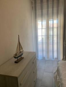 una camera da letto con un comò in legno con una modella di barca di La casa di Ely a Viareggio