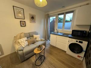 ヴァランシエンヌにあるLeRelaisdOdile - Studio Confort - Proche Hôpital - Idéal Couple & Travailleur- Accès Autoroute Rapideのソファとテーブルのあるリビングルーム +45枚の写真