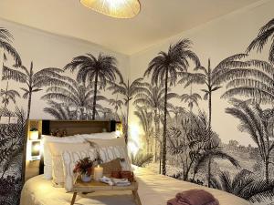 ヴァランシエンヌにあるLeRelaisdOdile - Studio Confort - Proche Hôpital - Idéal Couple & Travailleur- Accès Autoroute Rapideのヤシの木の壁画が施されたベッドルーム