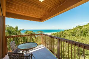 a balcony with a table and chairs and the ocean at Praia do Rosa - Reserva Pilger in Praia do Rosa