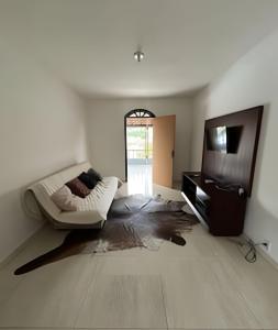 ein Wohnzimmer mit Sofa und Fernseher in der Unterkunft Bela casa 3 quartos perto do Buritis in Belo Horizonte + 24 Fotos