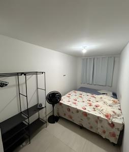 a bedroom with a bed and a chair in it at Bela casa 3 quartos perto do Buritis in Belo Horizonte