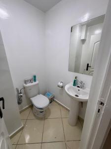 a white bathroom with a toilet and a sink at appartement a jawharat atlass 2 in Beni Mellal