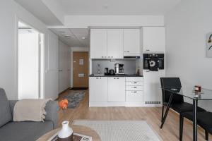 a kitchen and living room with a couch and a table at Modern 1BR Apartment in Kaleva next to Tram Line in Tampere