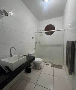a white bathroom with a sink and a toilet at Casa 5 quartos entre Centro e Pampulha in Belo Horizonte