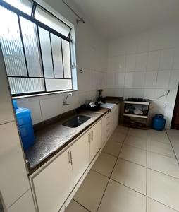 a small kitchen with a sink and a window at Casa 5 quartos entre Centro e Pampulha in Belo Horizonte +37 photos