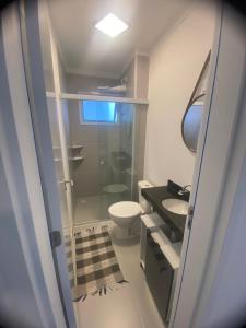 um banheiro com chuveiro, vaso sanitário e pia em Studio para locação Pereque-Açu em Ubatuba