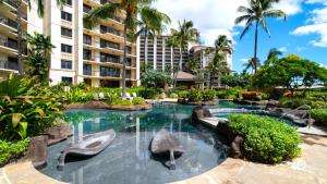 a swimming pool at a hotel with a resort at KBM Resorts FREE CAR Beach Villas at Ko Olina BVK-B-308 Beachfront Villa in Kapolei