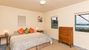 a bedroom with a bed and a window at Taupo Bay Beach House in Totara North