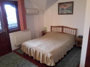 um pequeno quarto com uma cama e uma janela em Pensiunea Doina & Jenő em Târgu-Mureş