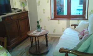 a living room with a couch and a table at La Calougeotte Jeanne in Saint-Jean-du-Marché