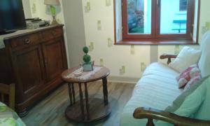 - un salon avec un canapé et une table dans l'établissement La Calougeotte Jeanne, à Saint-Jean-du-Marché