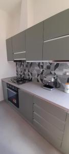 a kitchen with a stove and white cabinets at La Poltrona del Diavolo in Montenero