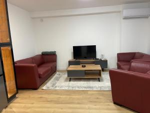 a living room with two red couches and a tv at Hana's Apartment in Peje