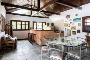 a dining room with a glass table and chairs at Casa na Marina com piscina churrasqueira e píer in Guarujá