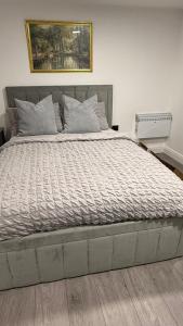 a bedroom with a large bed with a painting on the wall at Irtaza charming suite in Waterlooville