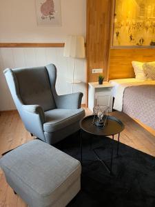 a bedroom with a bed and a chair and a table at Apartments Neckarsulm in Neckarsulm