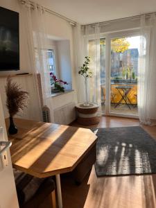 a living room with a wooden table and a window at Apartments Neckarsulm in Neckarsulm