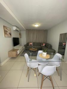a living room with a couch and a table and chairs at Windhoek Cozy stay in Windhoek