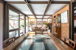 a living room with a glass table in the middle at Casa na Marina com piscina churrasqueira e píer in Guarujá