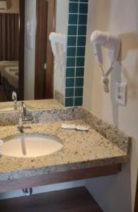 un bancone del bagno con lavandino e telefono di Hotel Resort 2025 a Olímpia