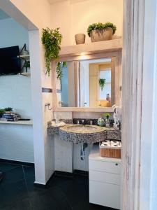 a bathroom with a sink and a mirror at Flat Piemonte Apart in Serra Negra
