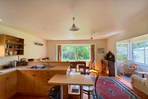 a kitchen and living room with a table and chairs at 8 Leamington Street in Hanmer Springs
