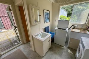 a bathroom with a sink and a washing machine at 8 Leamington Street in Hanmer Springs +16 photos