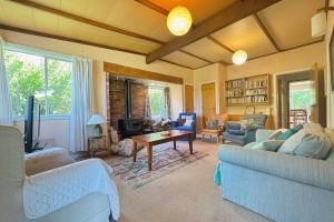 a living room with two couches and a table at 8 Leamington Street in Hanmer Springs