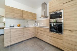 a kitchen with wooden cabinets and a stainless steel oven at House Villa Gold in Splitska