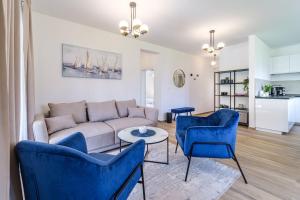 a living room with a couch and blue chairs at House Villa Gold in Splitska