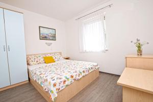a bedroom with a bed and a window at Apartment Marigold in Sveti Filip i Jakov