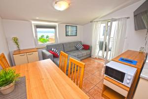 a living room with a table and a couch at Apartment Marigold in Sveti Filip i Jakov