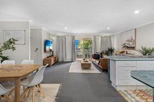 a kitchen and living room with a table and chairs at Oceanside Cove in Gold Coast