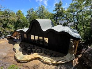 梅利佩乌科Conguillio Lava Cave的一座有着黑色屋顶和黄色楼梯的儿童游戏屋