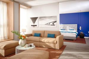 a living room with a couch and a bed at MLOFT Apartments München in Munich