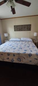 a bedroom with a bed with a blue floral bedspread at The Lake House in Hillsboro